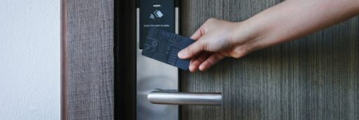 Hotel, vakantiehuisje of B&B, hier zie je een hand die met een hotelcard de kamerdeur van een hotel openmaakt